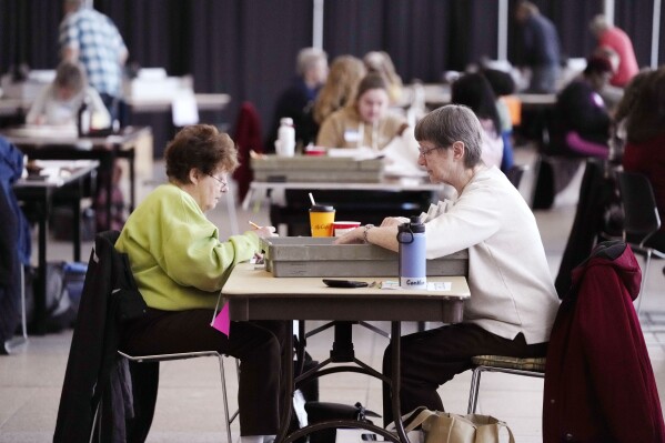 Election workers sort through absentee ballots, Tuesday, Feb. 27, 2024, in Warren, Mich. Michigan is the last major primary state before Super Tuesday and a critical swing state in November’s general election. (AP Photo/Carlos Osorio)