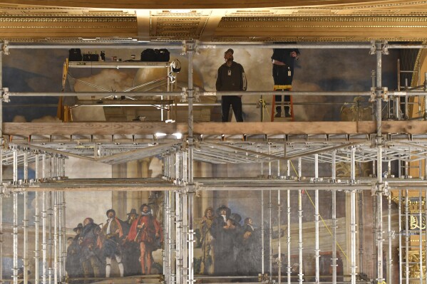 Workers on scaffolding set up in Pennsylvania's House of Representatives fix damage from a water leak on the ceiling, Feb. 2, 2024, in Harrisburg, Pa. Normally, the House chamber would host Gov. Josh Shapiro's budget address to a joint session of the state House and Senate on Tuesday, but instead Shapiro will deliver his address in the Capitol Rotunda.(AP Photo/Marc Levy)