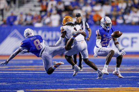 Boise State safety Seyi Oladipo (23) reaches for the ball for an interception after Boise State cornerback Markel Reed (8) tipped the ball away from the hands of UTEP wide receiver Tyrin Smith (1) during the second half of an NCAA college football game Friday, Sept. 10, 2021, in Boise, Idaho. (AP Photo/Steve Conner)