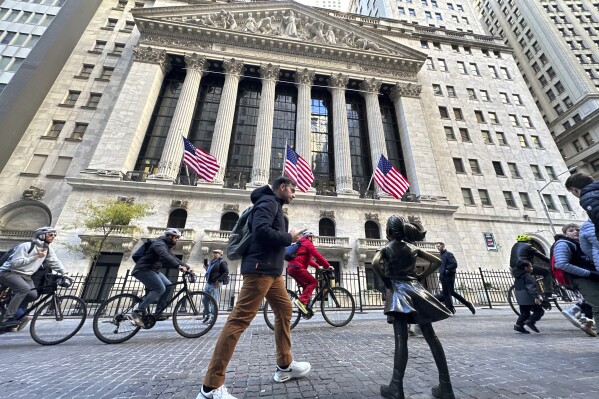 A man passes the "Fearless Girl" statue in front of the New York Stock Exchange in New York on Friday, November 3, 2023. (AP Photo/Ted Shaffrey)