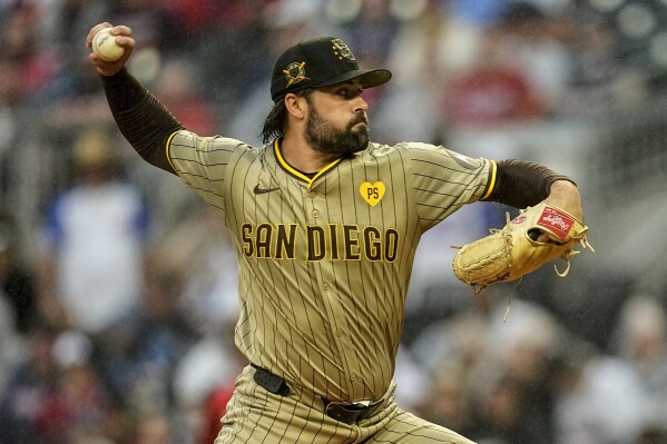 San Diego Padres pitcher Matt Waldron (61) deleivers in the rain in the first inning of a baseball game against the Atlanta Braves, Friday, May 17, 2024, in Atlanta. (AP Photo/Mike Stewart)