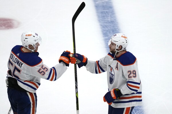 Edmonton Oilers center Leon Draisaitl (29) is congratulated by left wing Dylan Holloway (55) for an overtime goal against the Boston Bruins in an NHL hockey game Tuesday, March 5, 2024, in Boston. The Oilers won 2-1. (AP Photo/Charles Krupa)