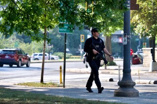 A U.S. Secret Service officer searches the area after Christopher Haynes, escaped custody at George Washington University Hospital on Wednesday, Sept. 6, 2023, in Washington. The George Washington University community in the nation's capital has been told to shelter in place after a homicide suspect escaped custody at the university's hospital. (Craig Hudson//The Washington Post via AP)