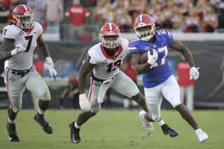 Florida running back Dameon Pierce (27) rushes for yardage past Georgia linebackers Adam Anderson (19) and Quay Walker (7) during the second half of an NCAA college football game, Saturday, Oct. 30, 2021, in Jacksonville, Fla. (AP Photo/Phelan M. Ebenhack)