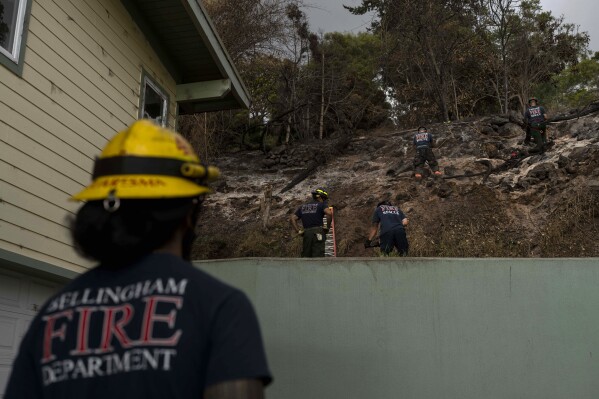 Firefighters clear debris in Kula, Hawaii, Tuesday, Aug. 15, 2023, following wildfires that devastated parts of the Hawaiian island of Maui. (AP Photo/Jae C. Hong)