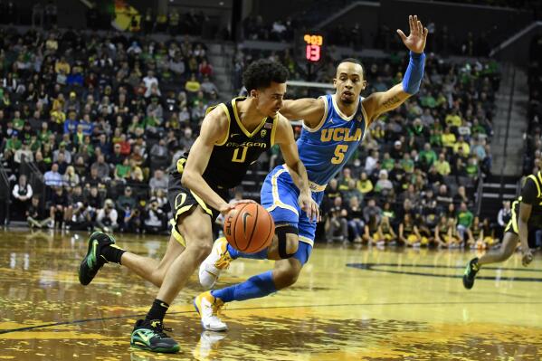 Oregon guard Will Richardson (0) drives to the basket as UCLA guard Amari Bailey (5) applies pressure during the first half of an NCAA college basketball game Saturday, Feb. 11, 2023, in Eugene, Ore. (AP Photo/Andy Nelson)