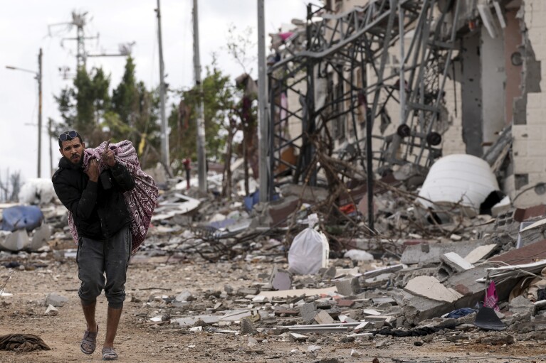 2023 m. lapkričio 28 d., antradienį, palestinietis renka savo daiktus į pietryčius nuo Gazos miesto. Penktąją laikinųjų paliaubų tarp Hamas ir Izraelio dieną.  (AP nuotrauka / Adelis Hanna)