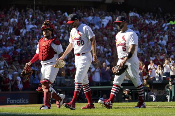 St. Louis Cardinals catcher Yadier Molina, left, starting pitcher Adam Wainwright (50) and first baseman Albert Pujols (5) walk off the field together as they are all removed at the from a baseball game against the Pittsburgh Pirates same time in the fifth inning Sunday, Oct. 2, 2022, in St. Louis. (AP Photo/Jeff Roberson)