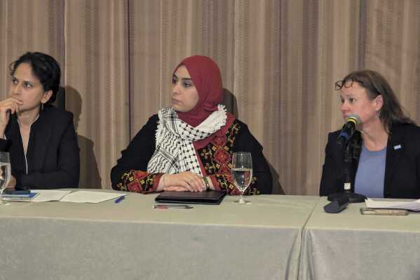 Mapheze Saleh, center, wife of arrested and detained Georgetown University scholar Badar Khan Suri, listens during a press conference about her husband's release following his hearing at Federal District Court for the Eastern District of Virginia, in Alexandria, Va., Thursday, May 14, 2025 (AP Photo/Nathan Ellgren)