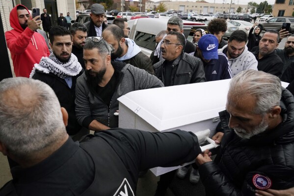 Family members of Wadea Al Fayoume bring his casket into Mosque Foundation in Bridgeview, Ill., Monday, Oct. 16, 2023. An Illinois landlord accused of fatally stabbing the 6-year-old Muslim boy and seriously wounding his mother was charged with a hate crime after police and relatives said he singled out the victims because of their faith and as a response to the war between Israel and Hamas. (AP Photo/Nam Y. Huh)