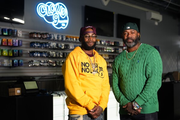 Cloud 9 Cannabis CEO and co-owner Sam Ward Jr., left, and co-owner Dennis Turner pose at their shop, Thursday, Feb. 1, 2024, in Arlington, Wash. Cloud 9 is one of the first dispensaries to open under the Washington Liquor and Cannabis Board's social equity program, established in efforts to remedy some of the disproportionate effects marijuana prohibition had on communities of color. (AP Photo/Lindsey Wasson)