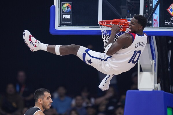 U.S. guard Jalen Brunson (11) reacts after a dunk over Jordan center Ahmad Dwairi (44) during the first half of a Basketball World Cup group C match in Manila, Philippines Wednesday, Aug. 30, 2023. (AP Photo/Michael Conroy)