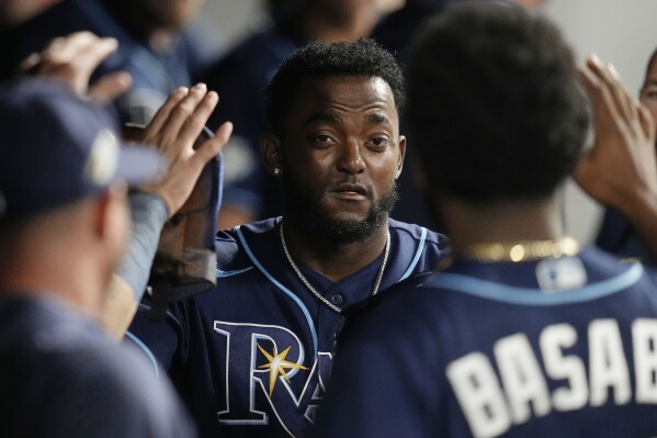 FILE - Tampa Bay Rays' Vidal Bruján is congratulated in the dugout after scoring in the 11th inning of the team's baseball game against the Cleveland Guardians, Sept. 2, 2023, in Cleveland. Bruján and right-hander Calvin Faucher were acquired by the Miami Marlins on Friday, Nov. 17, from the Rays for minor league right-hander Andrew Lindsey and infielder Erick Lara plus a player to be named or cash, the Marlins said. (AP Photo/Sue Ogrocki, File)