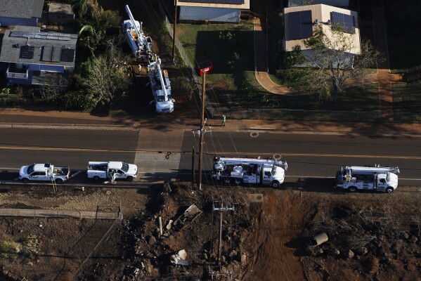 Utility crews work on a power line along Lahainaluna Road, in Lahaina, Hawaii, on Aug. 11, 2023. When the winds of Hurricane Dora lashed Maui Aug. 8, they struck bare electrical lines the Hawaiian electric utility had left exposed to the elements. (Stephen Lam/San Francisco Chronicle via AP)