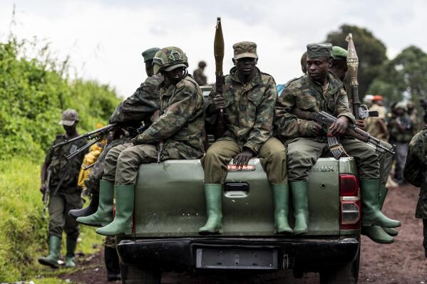 M23 rebels prepare to leave after a ceremony to mark the withdrawal from their positions in the town of Kibumba, in the eastern of Democratic Republic of Congo, Friday, Dec. 23, 2022. M23 rebels retreated from a village in eastern Congo Friday in the group's first withdrawal from an occupied village since it seized swaths of land months ago. (AP Photo/Moses Sawasawa)