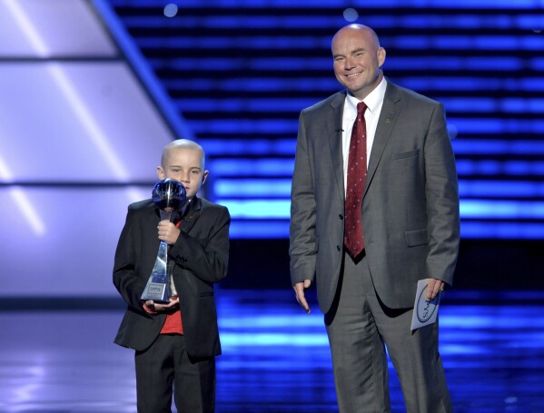 Jack Hoffman, left, accepts the award for best moment at the ESPY Awards, July 17, 2013, at Nokia Theater in Los Angeles. At right is Andy Hoffman. (Photo by John Shearer/Invision/AP, File)