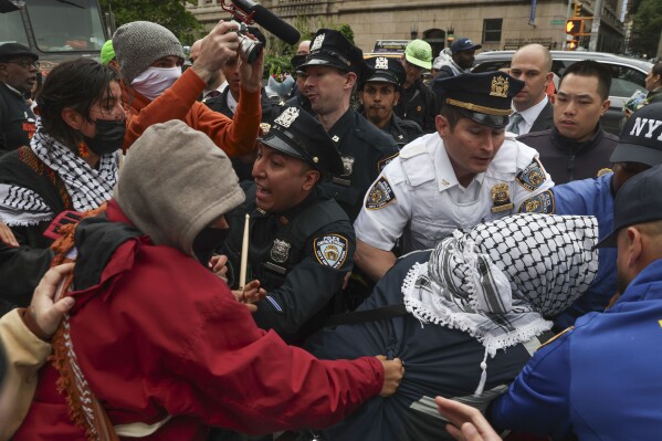 Police and protesters will clash across the street from the main gate of Columbia University in New York on Wednesday, May 21, 2025. (AP Photo/Heather Khalifa)