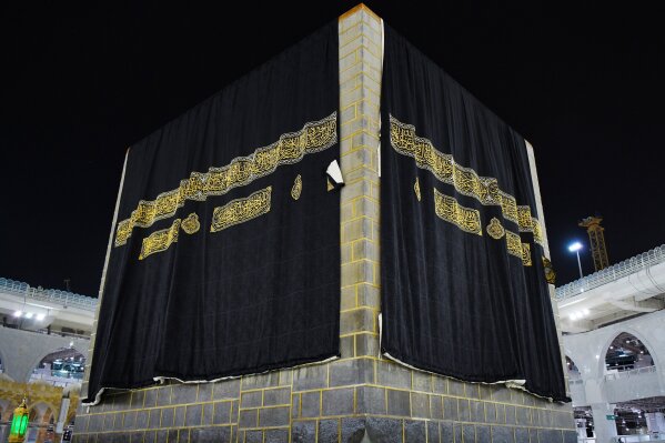 A new kiswa, or covering, is placed atop Islam's holiest site the Kaaba in Mecca on July 29, 2020. The gold-stitched black covering is changed each year during the hajj pilgrimage ahead of the Eid al-Adha celebrations. This year's hajj was dramatically scaled down from 2.5 million pilgrims to as few as 1,000 due to the coronavirus pandemic. (Saudi Media Ministry via AP)