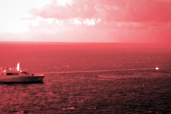In this handout infrared photo from the U.S. Marine Corps, the USS Portland fires a laser weapon system at a target floating in the Gulf of Aden on Tuesday, Dec. 14, 2021. The U.S. Navy announced Wednesday it tested a laser weapon and destroyed a floating target in the Mideast, a system that could be used to counter bomb-laden drone boats deployed by Yemen's Houthi rebels in the Red Sea. (Staff Sgt. Donald Holbert/U.S. Marine Corps via AP)