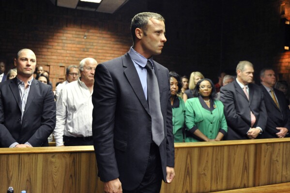 FILE - Olympian Oscar Pistorius stands following his bail hearing in Pretoria, South Africa, Tuesday, Feb. 19, 2013. Pistorius could be granted parole on Friday, Nov. 24, 2023 after nearly 10 years in prison for killing his girlfriend. The double-amputee Olympic runner was convicted of a charge comparable to third-degree murder for shooting Reeva Steenkamp in his home in 2013. He has been in prison since late 2014. (AP Photo, File)
