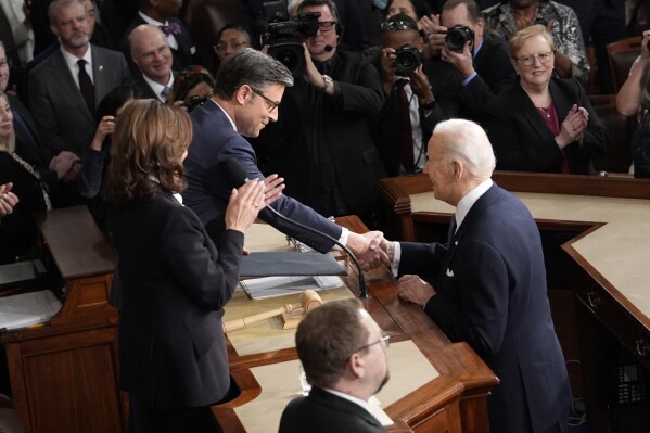 President Joe Biden shakes hands with Speaker of the House Mike Johnson, as Vice President Kamala Harris looks on, as he arrives to deliver his State of the Union address to a joint session of Congress, at the Capitol in Washington, Thursday, March 7, 2024. (AP Photo/J. Scott Applewhite)