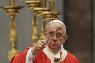 Pope Francis asperges holy water as he celebrates a Pentecost mass in St. Peter's Basilica, at the Vatican, Sunday, May 20, 2018. (AP Photo/Gregorio Borgia)
