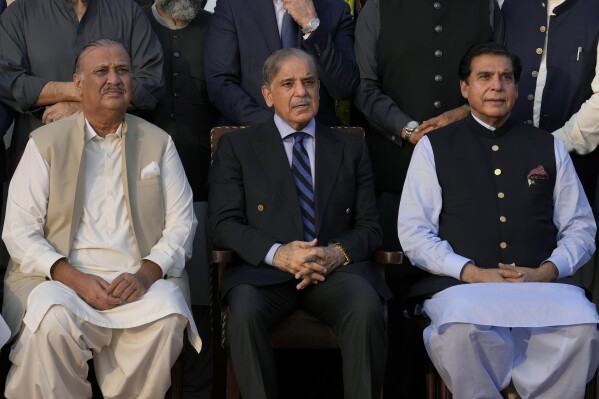 Pakistan's Prime Minister Shehbaz Sharif, center, Speaker Raja Pervez Ashraf, left, and Raja Riaz, opposition leader in National Assembly pose for a photo with lawmakers of the National Assembly at the end of the last session of the current parliament, in Islamabad, Pakistan, Wednesday, Aug. 9, 2023. Pakistan's prime minister took a formal step Wednesday toward dissolving parliament, starting a possible countdown to a general election, as his chief political rival fought to overturn a corruption conviction that landed him in a high-security prison over the weekend. (AP Photo/Anjum Naveed)