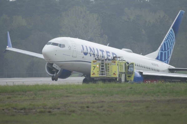 A United Airlines jet sits in a grassy area after leaving the taxiway Friday, March 8, 2024, at George Bush Intercontinental Airport in Houston. No passenger or crew injuries have been reported, according to a United Airlines spokesperson. (Jason Fochtman/Houston Chronicle via AP)