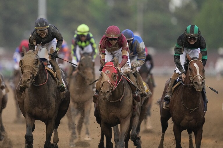 Brian Hernandez Jr. rijdt op Mystic Dan, rechts, en galoppeert naar de finish om de 150e editie van de Kentucky Derby op Churchill Downs op zaterdag 4 mei 2024 in Louisville, Ky. te winnen. (AP Photo/Brynn Anderson)