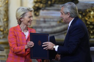 FILE - European Commission President Ursula von der Leyen, left, and Argentina's President Alberto Fernandez, exchange folders during a meeting at the government house in Buenos Aires, Argentina, Tuesday, June 13, 2023. Argentina’s outgoing government said Monday, Dec. 4, that it won't support the signing of a long-delayed trade deal between the European Union and the South American bloc Mercosur during a summit this week in Brazil even though the incoming Argentine government has expressed support for the deal. (AP Photo/Natacha Pisarenko, File)