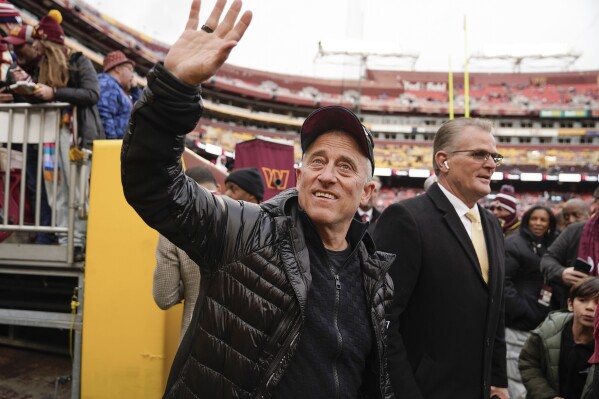 Washington Commanders owner Josh Harris waving to fans during pregame warmups before the start of the first half of an NFL football game against the Dallas Cowboys, Sunday, Jan. 7, 2024, in Landover, Md. (AP Photo/Jessica Rapfogel)