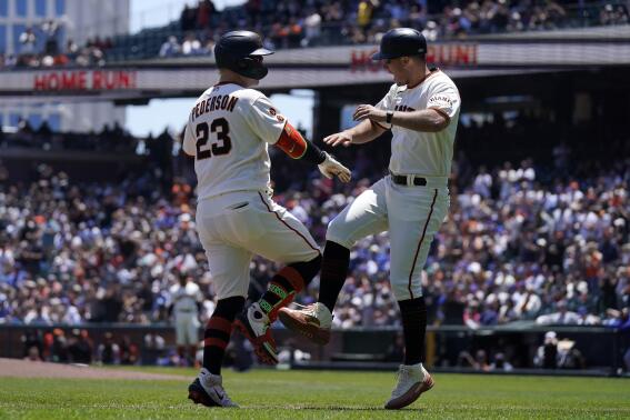 San Francisco Giants' Joc Pederson (23) is congratulated by third base coach Mark Hallberg after hitting a two-run home run during the first inning of a baseball game against the Chicago Cubs in San Francisco, Sunday, June 11, 2023. (AP Photo/Jeff Chiu)