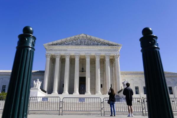 People take photos of U.S. Supreme Court on Tuesday, Oct. 11, 2022, in Washington. (AP Photo/Mariam Zuhaib)
