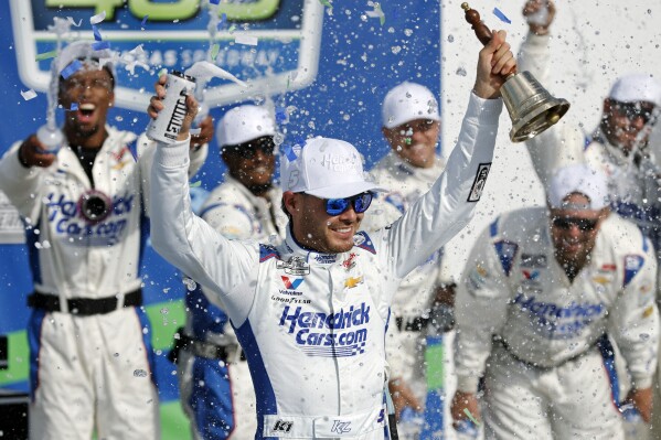 Kyle Larson, center, celebrates in Victory Lane after winning a NASCAR Cup Series auto race at Kansas Speedway in Kansas City, Kan., Sunday, May 11, 2025. (AP Photo/Colin E. Braley)