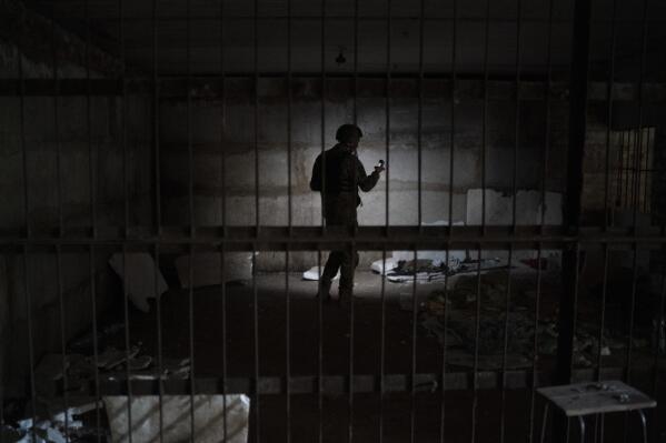 FILE - A Ukrainian serviceman stands in a basement which, according to Ukrainian authorities, was used as a torture cell during the Russian occupation, in the retaken village of Kozacha Lopan, Ukraine, Sept. 17, 2022. In a deliberate, widespread campaign, Russian forces systematically targeted influential Ukrainians, nationally and locally, to neutralize resistance through detention, torture and executions, an Associated Press investigation has found. The strategy appears to violate the laws of war and could help build a case for genocide. (AP Photo/Leo Correa, File)