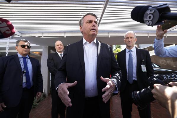 Former Brazilian President Jair Bolsonaro speaks to the press outside his home after Federal Police agents carried out a search and seizure warrant in Brasilia, Brazil, Wednesday, May 3, 2023. When asked about the search of Bolsonaro’s home in Brasilia, the Federal Police press office gave a statement saying officers were carrying out searches and arrests related to the introduction of fraudulent data related to the COVID-19 vaccine into the nation’s health system. (AP Photo/Eraldo Peres)