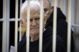 FILE - Ales Bialiatski, the head of Belarusian Vyasna rights group, sits in a defendants' cage during a court session in Minsk, Belarus, on Thursday Jan. 5, 2023. A Belarusian court has sentenced Ales Bialiatski, Belarus' top human rights advocate and one of the winners of the 2022 Nobel Peace Prize, to 10 years in prison. Bialiatski and three other top figures of the Viasna human rights center he founded were convicted of financing anti-government protests. (Vitaly Pivovarchyk/BelTA Pool Photo via AP, File)