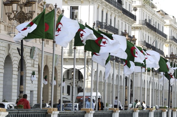 Algeria's flags fly Wednesday, April 16, 2025 in Algiers. (AP Photo/Fateh Guidoum, File)
