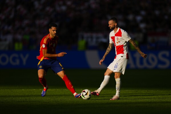 Croatia's Marcelo Brozovic, right, vies for the ball with Spain's Mikel Merino during a Group B match between Spain and Croatia at the Euro 2024 soccer tournament in Berlin, Germany, Saturday, June 15, 2024. Spain defeated Croatia 3-0. (AP Photo/Manu Fernandez)