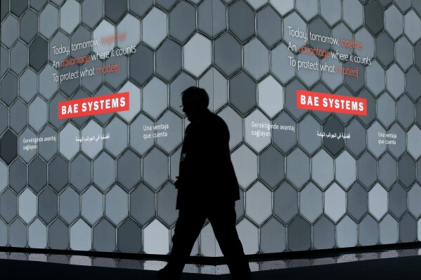 FILE - A man walks past a screen in the BAE Systems chalet at the Farnborough Airshow in Farnborough, England, on July 16, 2018. China announced sanctions Sunday, Jan. 7, 2024 on five American defense-related companies in response to U.S. arms sales to Taiwan and U.S sanctions on Chinese companies and individuals. (AP Photo/Matt Dunham, File)