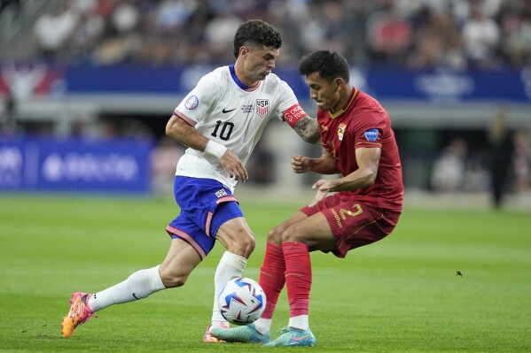  Christian Pulisic of the United States, left, and Bolivia's Jesus Sagredo battle for the ball during a Copa America Group C soccer match in Arlington, Texas, Sunday, June 23, 2024. (AP Photo/Tony Gutierrez)