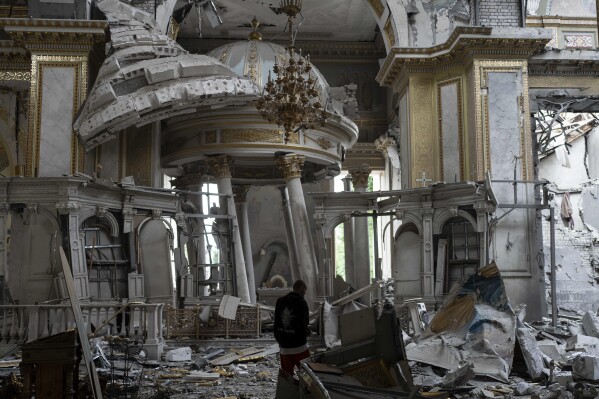 A church personnel inspects damages inside the Odesa Transfiguration Cathedral in Odesa, Ukraine, Sunday, July 23, 2023, following Russian missile attacks. In just a week, Russia has fired more than 125 missiles and drones at the Odesa region, hitting the historic city center that had been largely spared since the beginning of the war. (AP Photo/Jae C. Hong)