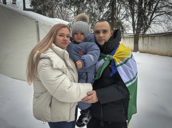 Kateryna Dmytryk, left, and husband Artem Dmytryk hold their son, Timur, after Artem was released from Russian captivity as a part of a prisoner swap in Kyiv, Ukraine, Feb. 9, 2024. (AP Photo/Vasilisa Stepanenko)