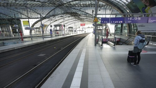 FILE - A person stands on the empty station platform at the main station in Berlin, Germany, Wednesday, Aug. 11, 2021. A German rail workers’ union says it’s prepared to take a long-running pay dispute with the main national railway operator to arbitration, which should head off strikes during the summer vacation period. (AP Photo/Michael Sohn, File)