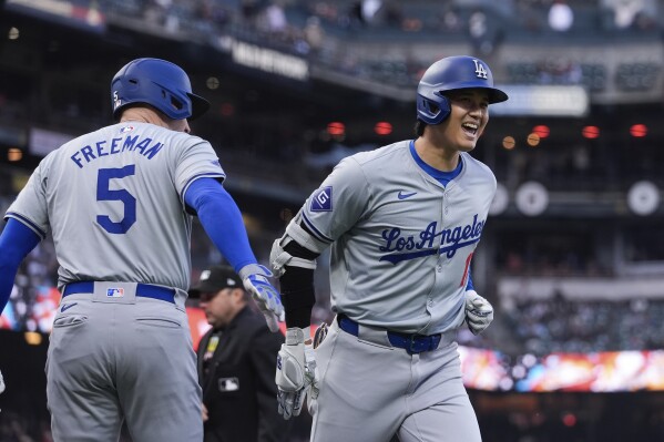 Los Angeles Dodgers' Shohei Ohtani, right, is congratulated by Freddie Freeman after his solo home run against the San Francisco Giants during the fourth inning of a baseball game Tuesday, May 14, 2024, in San Francisco. (AP Photo/Godofredo A. Vásquez)