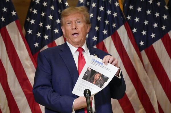 Former President Donald Trump holds up a copy of a story featuring New York Attorney General Letitia James while speaking during a news conference, Thursday, Jan. 11, 2024, in New York. Trump's lawyers presented closing arguments in his civil business fraud trial earlier in the day. (AP Photo/Mary Altaffer)