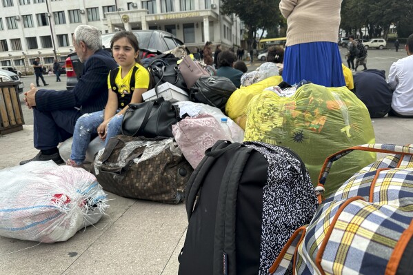 Ethnic Armenians gather in hope to leave Nagorno-Karabakh region for Armenia in the center of Stepanakert, Nagorno-Karabakh on Monday, Sept. 25, 2023. The separatist government of Nagorno-Karabakh announced Thursday that it will dissolve itself and the unrecognized republic will cease to exist by the end of the year, and Armenian officials said more than half of the population has already fled. (AP Photo/Ani Abaghyan)