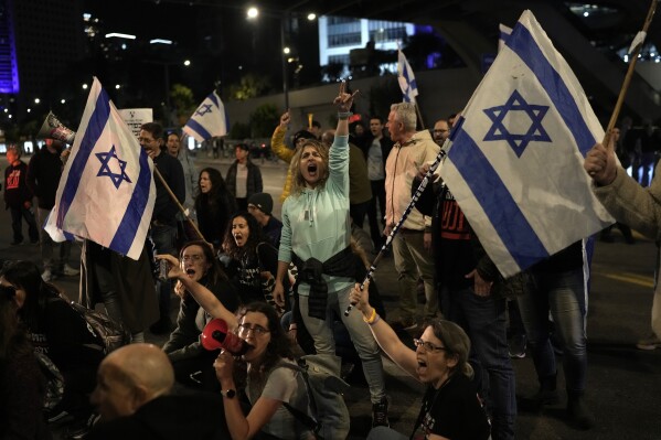 FILE - Protesters attempt to block a street during a demonstration to demand the release of the hostages taken by Hamas militants into the Gaza Strip during the Oct. 7th attack, in Tel Aviv, Israel, Saturday Jan. 20, 2024. After the Oct. 7 attack by Hamas, Israelis put aside their differences and rallied behind the war effort in Gaza. But as the war grinds on, the mood of the Israeli public is shifting and old divisions are reemerging. The catalyst is a rift over the polarizing leadership of Israeli Prime Minister Benjamin Netanyahu and a growing frustration with his management of the war. (AP Photo/Leo Correa, File)