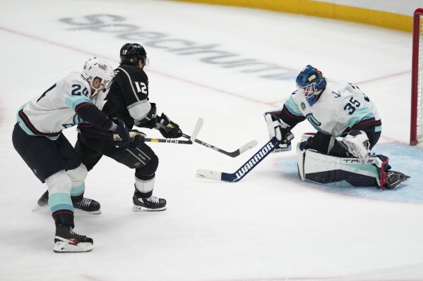 Seattle Kraken goaltender Joey Daccord (35) stops a shot by Los Angeles Kings left wing Trevor Moore (12) during the second period of an NHL hockey game Wednesday, Dec. 20, 2023, in Los Angeles. (AP Photo/Ashley Landis)