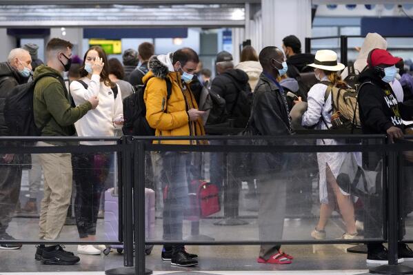 Travelers line up for flights at O'Hare International Airport in Chicago, Thursday, Dec. 30, 2021. (AP Photo/Nam Y. Huh)